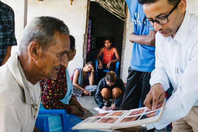 Leprosy doctor shows pictures of leprosy symptoms to contacts of leprosy patient
